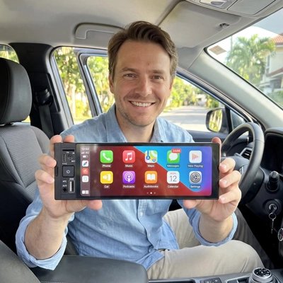 Autoradio carplay Roadix tenu par homme souriant