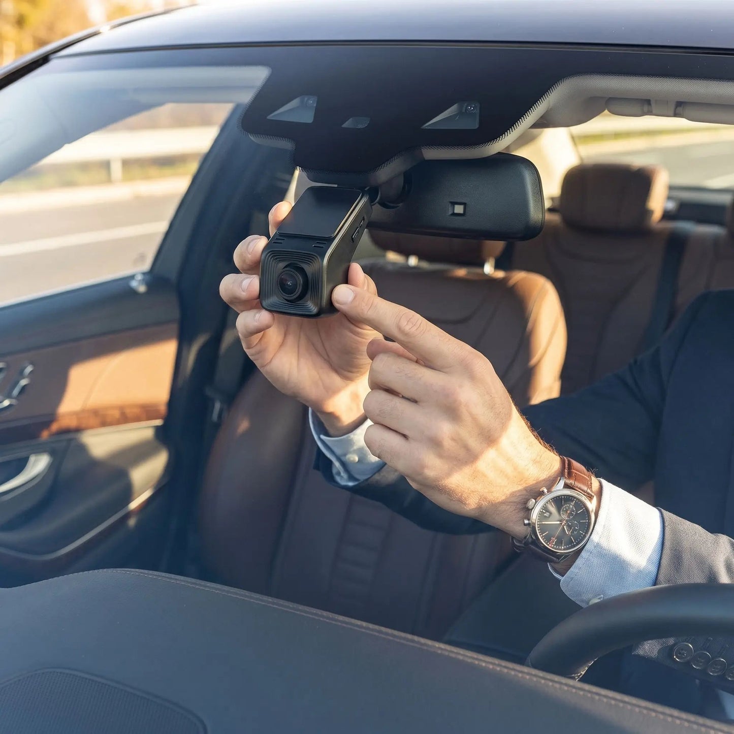 homme installe camera pour voiture sur pare-brise
